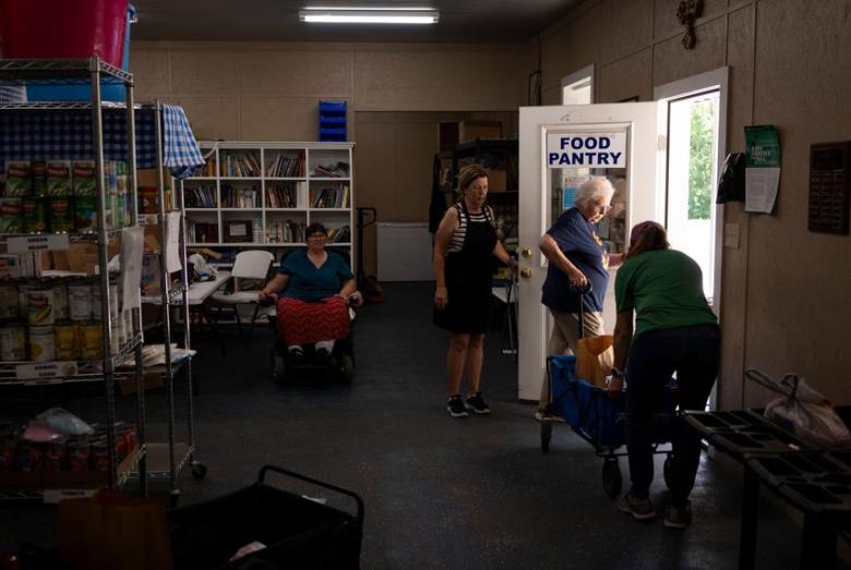 Volunteers and employees at the Leon Community Food Pantry and Clothes Closet in Jewett work together to cart food to a client on June 29, 2023. The grandfather of Kristy Vandergriff, pantry director, is the property owner of a part of the NRG Jewett Mine.